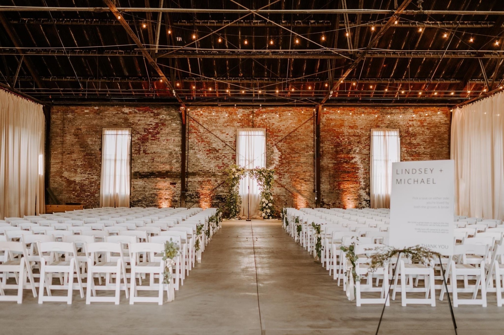 Ceremony aisle framed by string lights