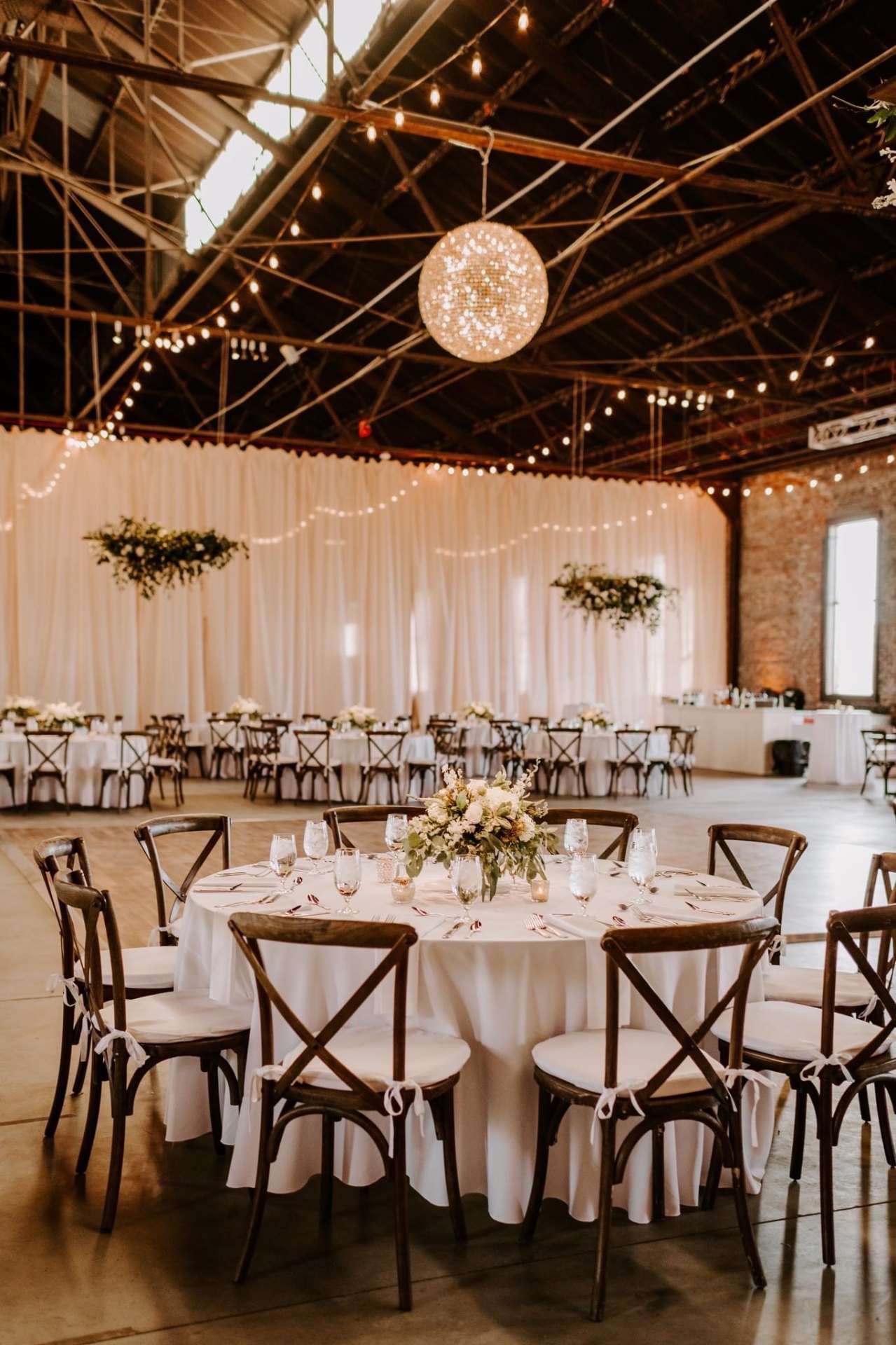 Round tables with crossback chairs and draped backdrop