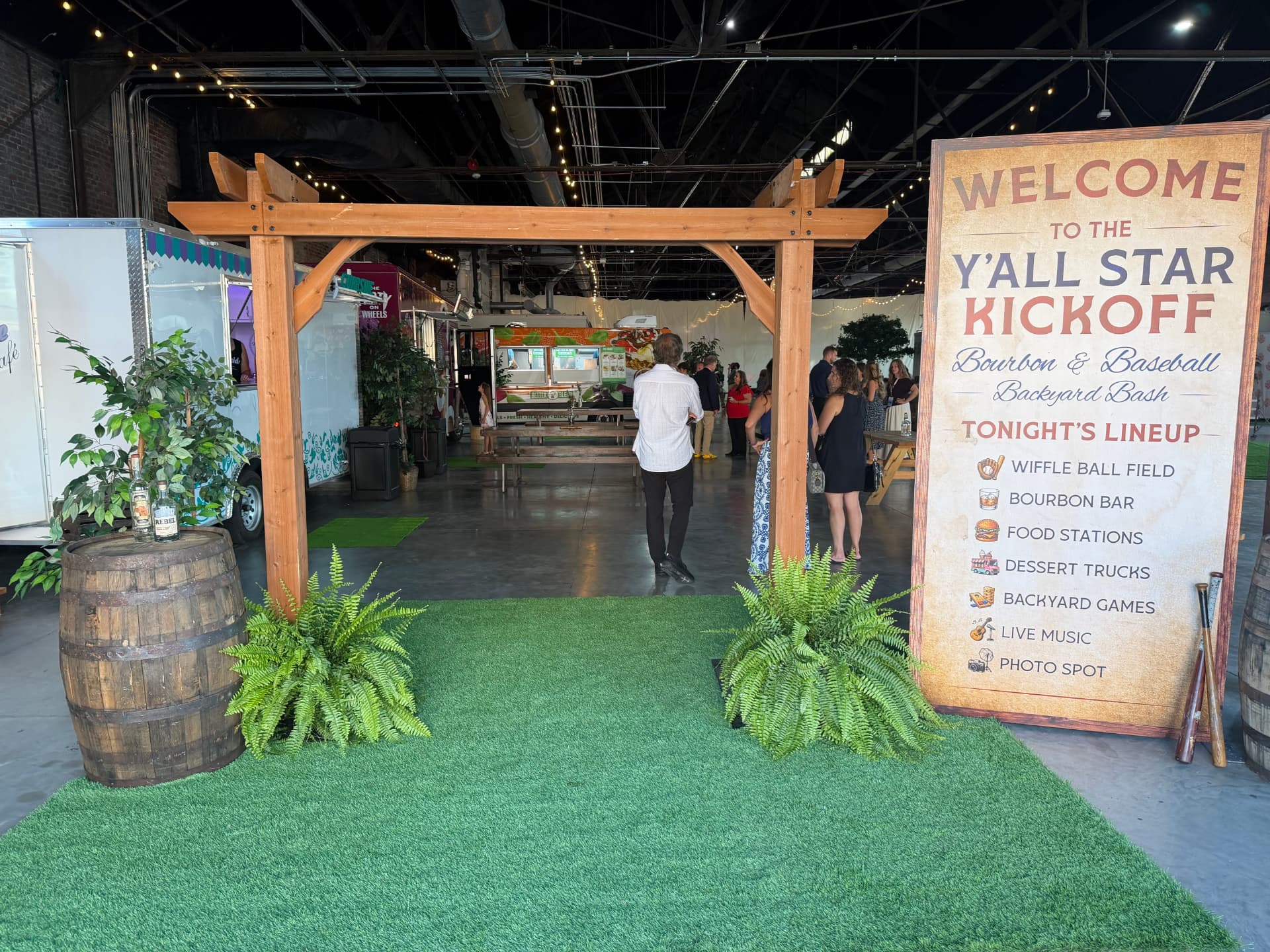 Indoor turf entrance with pergola, bourbon barrels and welcome sign
