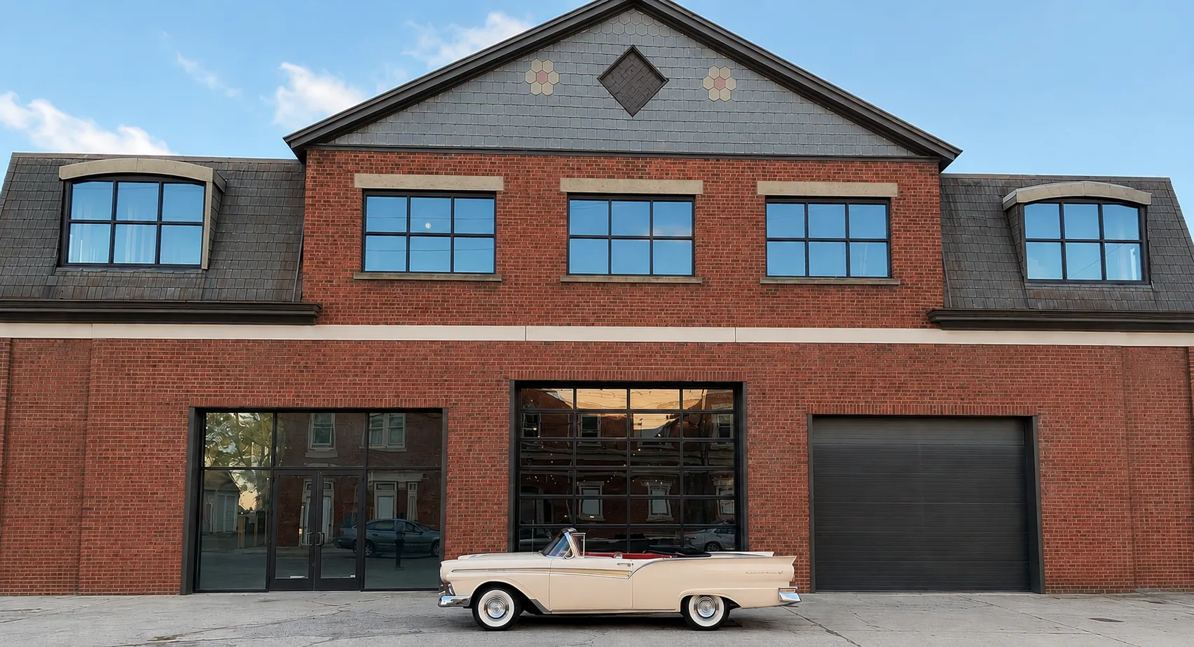 Front exterior of the Newport Car Barn with a vintage convertible parked outside