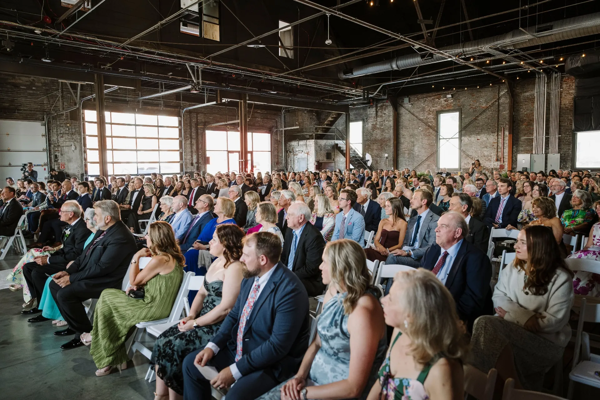 Wedding guests seated for ceremony inside the warehouse