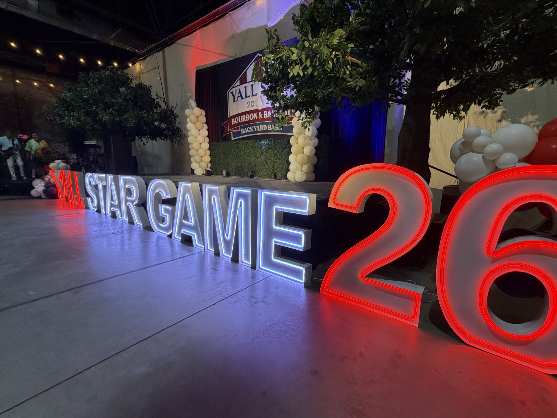 Glowing marquee letters on the event floor beside the stage
