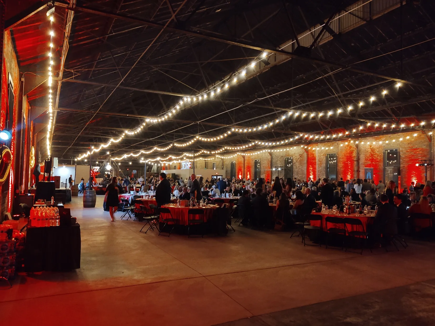 Fundraising gala filling the main hall beneath cafe string lights